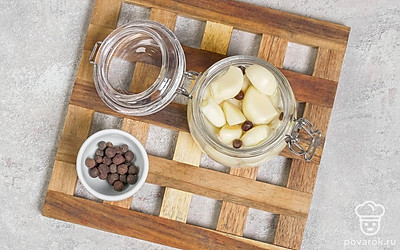 Всыпьте горошины перца, влейте доверху воду. Закройте плотно крышку и хорошенько потрясите. После этого уберите чеснок в холодильник на 3-5 дней.