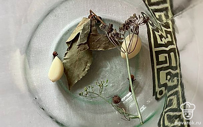 Кладем в литровую стерилизованную банку чеснок, зонтик укропа, душистый и черный перец горошком, гвоздику и лавровый лист.