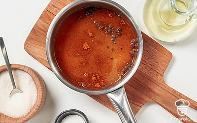 Приготовьте маринад. В другую кастрюлю налейте 500 мл воды, всыпьте все виды перца, сахар, соль и кориандр, добавьте чеснок, доведите до кипения и варите на медленном огне 3 минуты. Остудите маринад, добавьте в него уксус и подсолнечное масло, перемешайте.