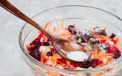 Приготовьте маринованную капусту. Всыпьте к овощам с клюквой сахар, соль, молотый перец и перемешайте капустную массу еще раз, тщательно ее растирая. Влейте масло и уксус, последний раз перемешайте. Затем поставьте на капусту широкую тарелку, а на нее поставьте какой-нибудь груз, например, бутыль с водой. Дайте капусте промариноваться несколько часов при комнатной температуре, затем поставьте в холодильник на 1-2 часа.