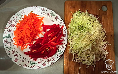 Нашинкуйте капусту, натрите морковь на крупной тёрке, перец нарежьте соломкой (и можно ещё пополам). 