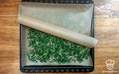 Отрежьте два листа пергамента соразмерных противню. Положите первый лист и выложите зелень поверх, равномерно распределяя ее по поверхности. Накройте вторым листом сверху и отправьте в духовку на 240 минут при температуре примерно 45 °C.