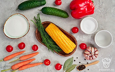 Вымойте овощи и зелень, обсушите их полотенцем. Очистите кукурузу от листьев, а морковь — от кожуры. Снимите с чеснока шелуху. Порежьте початки кукурузы и огурцы толстыми кружочками. Из перцев удалите семена и разрежьте их пополам. Достаньте банки и крышки, простерилизуйте их.