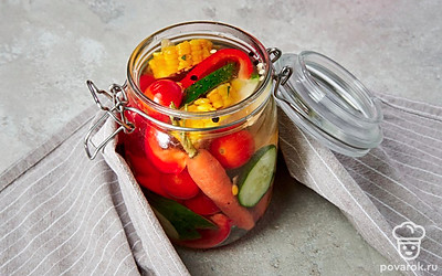 Замаринуйте овощи. Вложите в банки веточки укропа, огурцы, кукурузу, морковь, болгарский перец, помидоры и чеснок, влейте маринад и плотно закатайте крышки. Переверните банки и выложите на полотенце, оставьте их на 5 часов.