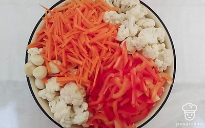 Подготовьте кастрюлю и отварите цветную капусту в подсоленной воде в течении 10 минут. В миске соедините все овощи, перемешайте и разложите в литровые банки. Налейте в кастрюлю 3 л воды, добавьте специи, сахар, соль, сухую аджику и приправу для корейских салатов.