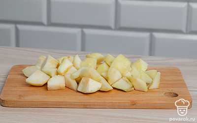 На разделочной доске нарежьте очищенные груши кубиками среднего размера.