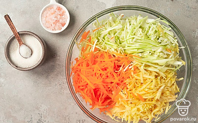 Подготовьте капусту к засолке. В глубокой миске соедините капусту, айву и морковь, добавьте соль и сахар. Хорошо смешайте и помните руками, капуста должна уменьшиться в объеме и дать сок.