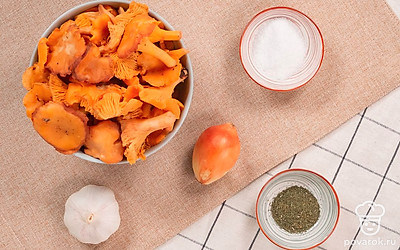 Лисички хорошо промойте, чтобы в них не было песка. Листья смородины и укроп промойте водой. Чеснок очистите от шелухи. Подготовьте банки и крышки для хранения засоленных грибов. Репчатый лук почистите и нарежьте половину тонкими кольцами.