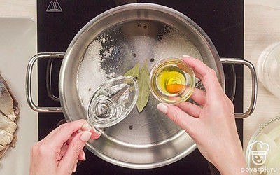 Сварите маринад для селедки. Положите в кастрюлю лавровый лист, черный перец горошком, всыпьте сахар и соль, влейте уксус и растительное масло. Добавьте воду и все перемешайте. Поставьте кастрюлю на огонь, дайте содержимому закипеть и варите 2-3 минуты. Проследите, чтобы соль и сахар полностью растворились. Выключите огонь, дайте маринаду полностью остыть.