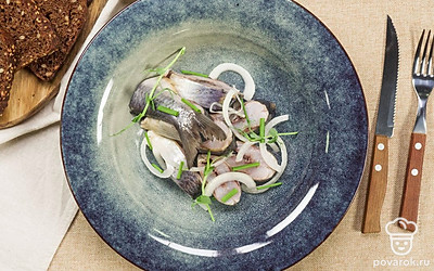 Перед подачей выложите сельдь с репчатым луком на блюдо, мелко порежьте зеленый лук и посыпьте им рыбу.