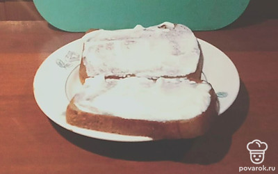Смажьте обе половинки хлеба сметаной. 