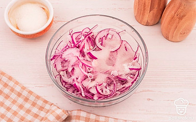 Выложите лук в глубокую миску. Добавьте сахар, соль, воду и уксус. Перемешайте.