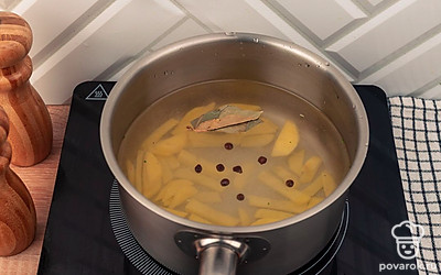 Картофель залейте водой, добавьте лавровый лист, черный перец горошком и поставьте большой огонь. После закипания убавьте огонь и варите в течение 10 минут.