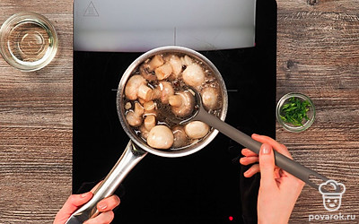 Приготовьте маринад. Для этого грибы переложите в ту же кастрюлю и залейте водой. Вода должна покрыть грибы. Добавьте растительное масло, соль, сахар, перец, лавровые листья, кориандр, гвоздику и чеснок. Варите маринад 10 минут на среднем огне. Затем добавьте уксус и варите еще 10 минут. Выключите огонь и оставьте шампиньоны остывать.