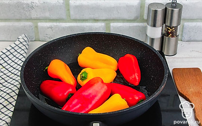 Возьмите глубокую сковородку, смажьте ее подсолнечным маслом, хорошо разогрейте и выложите на нее болгарский перец для обжарки.