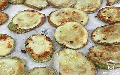 Выложите кружочки на салфетку, чтобы масло впиталось.