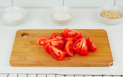 Нарежьте помидоры крупными дольками. Очистите зубчики чеснока.