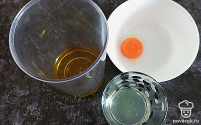 Масло перелить в чашу блендера. Желток аккуратно отделить от белка, чтобы желток оставался целым. Из лимона выдавить сок, удалить косточки.