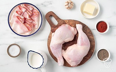 Помойте куриные окорочка, промокните их от излишков влаги бумажными полотенцами. Вымойте и почистите чеснок. Подготовьте сковороду, фольгу и глубокую форму для запекания.