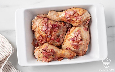 Переложите курицу в форму для запекания. Равномерно покройте курицу хрустящими кусочками бекона.