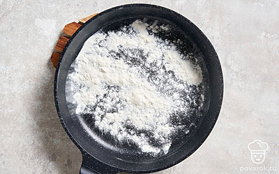Поставьте сухую сковороду на огонь немного больше среднего, как следует ее разогрейте. Насыпьте на сковороду просеянную муку.