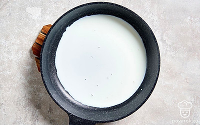 Налейте на сковороду 1/3 часть молока, слегка согрейте его на среднем огне. 