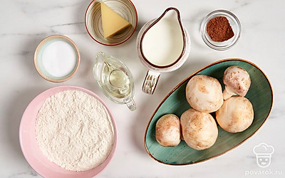 Вымойте шампиньоны и обсушите бумажными полотенцами, срежьте ножом темные пятнышки и почерневшее основание ножки грибов. Просейте муку. Подготовьте сковороду, сотейник и терку.
