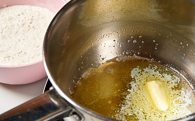 Поставьте на огонь сотейник с оставшимся 25 г масла. Дождитесь, когда оно растопится, а затем добавьте муку. Хорошо перемешайте до однородности.