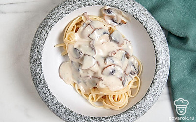 Выложите спагетти в тарелку. Полейте блюдо соусом бешамель с грибами, а затем подайте его на стол.