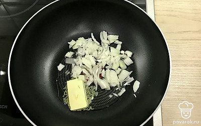 Обжарьте лук, нарезанный полукольцами, на смеси масел до румяности.