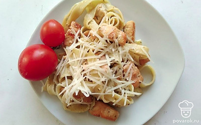 Разложите порции пасты с лососем и сливочным соусом на плоские тарелки и посыпьте тертым пармезаном. В качестве украшения используйте свежую зелень и овощи.