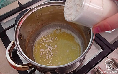 В растопленное масло постепенно добавляйте муку и мешайте. 