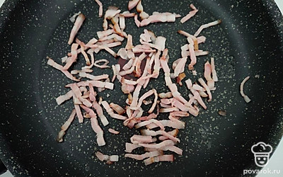 Бекон нарежьте тонкой соломкой и выложите на сухую разогретую сковороду. Обжарьте бекон до румяной корочки и переложите в тарелку.