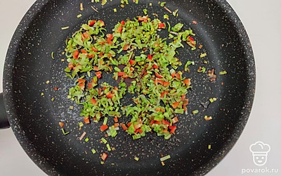 Лук-порей и острый перец нарежьте мелкими кусочками. Выложите нарезанный лук в сковороду и обжарьте на жире, который вытопился из бекона. Когда лук приобретет легкий румянец, добавьте измельченный перец и обжарьте еще несколько минут.