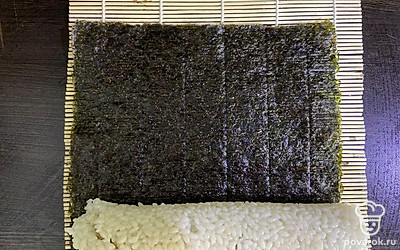 На другую половину выложите творожный сыр. Соедините 2 половинки и выдавите ролл на лист нори.