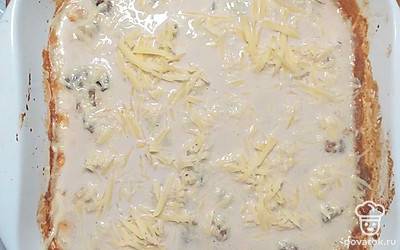 Достать грибы, перемешать, посыпать тертым сыром. Температуру в духовке убавить до 180 градусов, запекать еще 10 минут до расплавления сыра.