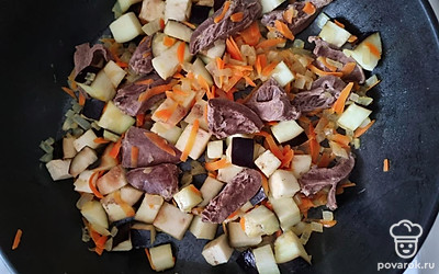 Баклажан нарезать крупными кубиками, добавить его на сковороду вместе с сердечками. Перемешать, тушить на медленном огне около 10 минут.