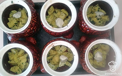 Равномерно выложите картофель во все горшочки. На картофель положите по 1 чайной ложке плавленого сливочного сыра.