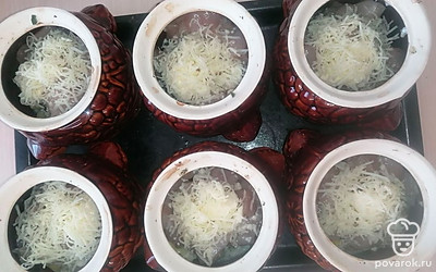 Распределите весь натертый сыр равномерно по всем горшочкам.