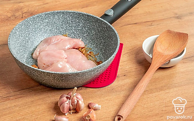 Начните готовить курицу. Ломтики курицы добавьте к луку. Готовьте, помешивая, 3-4 минуты, пока мясо не побелеет.