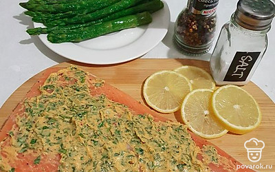 Распределите соус по всей поверхности рыбы. Положите форель вместе со спаржей на противень. Добавьте несколько круглых слайсов лимона.
