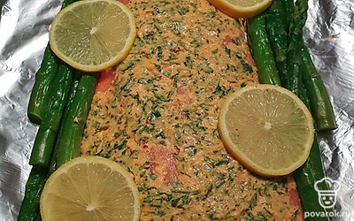 Поставьте противень в разогретую духовку и выпекайте форель в течение 15 минут.