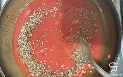 Добавьте томатный соус к чесноку. Сюда же добавьте прованские травы. Тушите соус 2-3 минуты, постоянно помешивая.