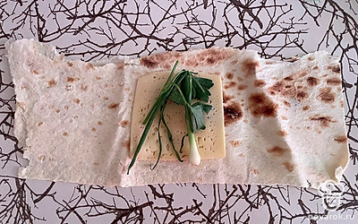 Выложите свежую зелень поверх сыра.