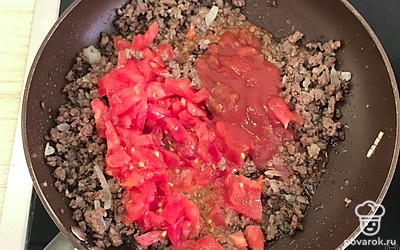 В обжаренный с луком фарш выложить помидоры и протертые томаты. Перемешать. Обжаривать 5 минут вместе, постоянно помешивая. Добавить воды. Убавить огонь и тушить над закрытой крышкой еще минут 20.