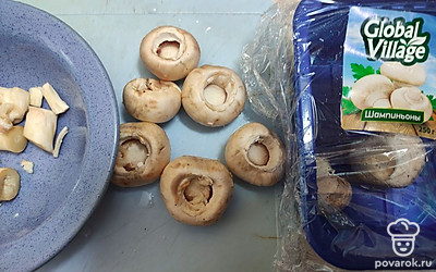 Шампиньоны очистите от земли, отделите крышечки от ножек. Ножки нарежьте и обжарьте до готовности. 
