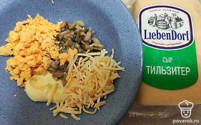 Сыр натрите на терке, желтки раскрошите. Смешайте желтки, сыр, грибы, майонез и поместите начинку в белки. 