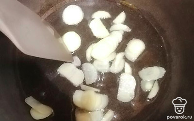 Чеснок режем кружочками и немного обжариваем на растительном масле, чтобы масло пропиталось ароматом чеснока.