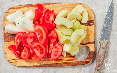 Вырежьте у помидоров плодоножки. Нарежьте помидоры вместе с луком крупными дольками. Снимите с яблок кожуру и уберите сердцевину, а мякоть нарежьте средними дольками. 