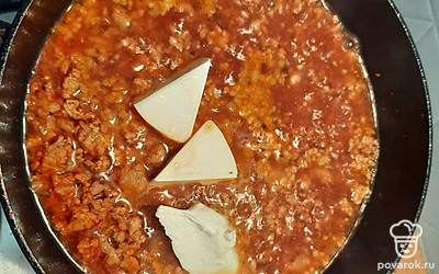 Добавить ложку сметаны и плавленый сыр (у меня два треугольника). Перемешать и накрыть крышкой. Так как сыр сразу не тает, перемешать ещё раз через 5 минут.